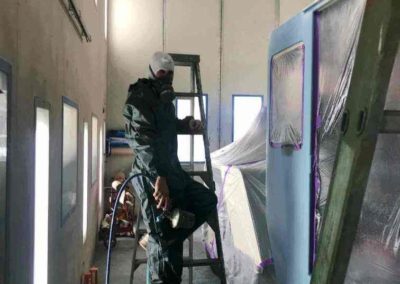 One of the spray painting technicians respraying sections of a crane
